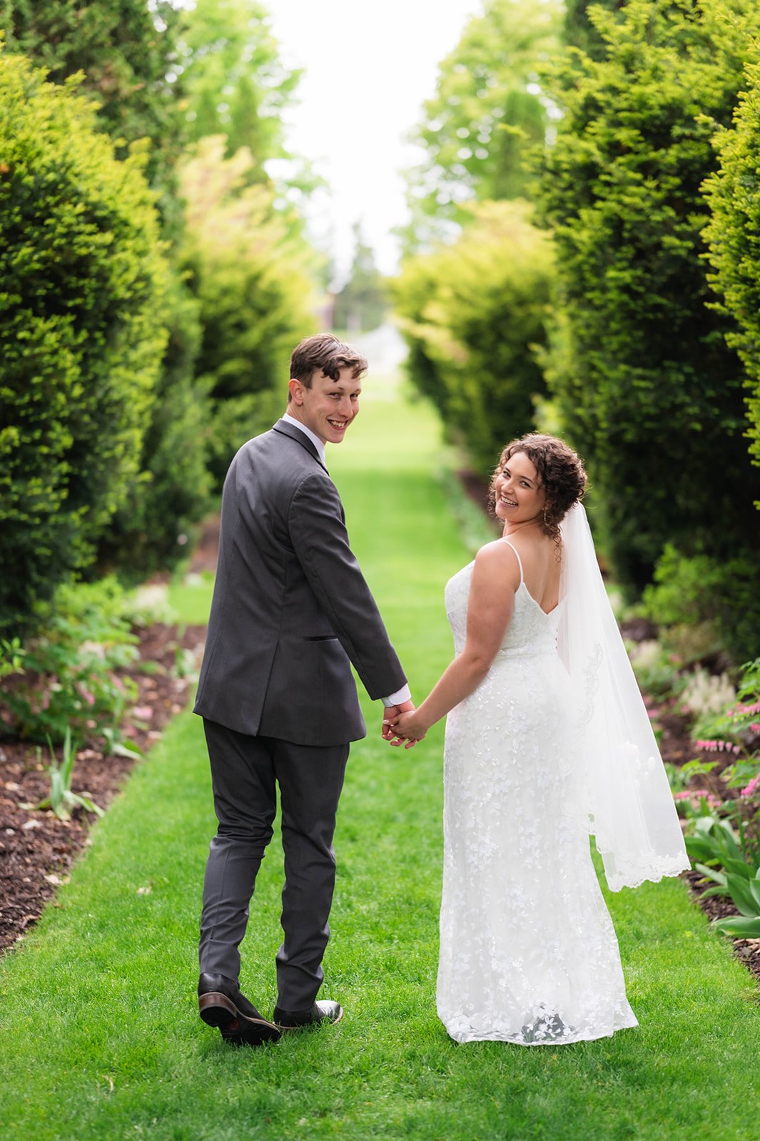 Newlyweds standing together in a natural landscape