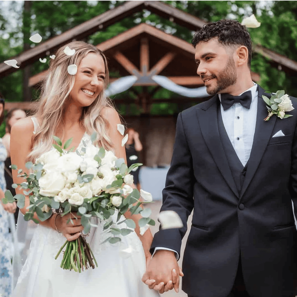 Newlyweds smiling while guests celebrate around them