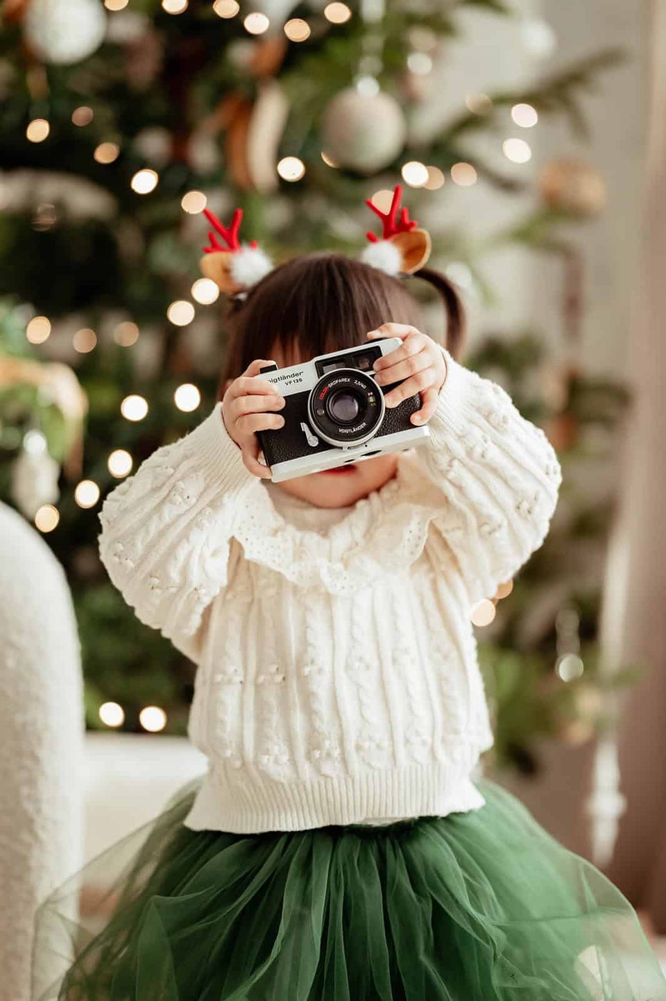 Little girl holding camera up in front of her face